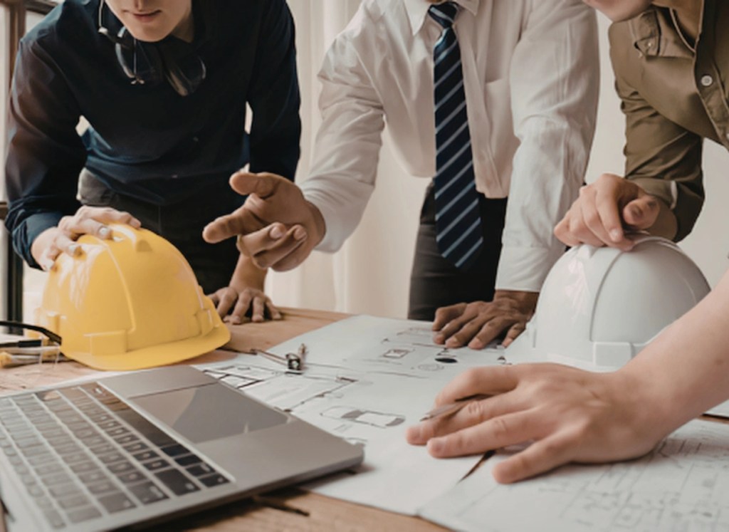 Project manager coordinating pre-engineered steel building plans with civil engineers and architects in Ontario Canada